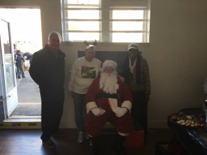 Mayor Moor, Asbury Park Toy Drive's Connie Breech and Councilwoman Yvonne Clayton join Santa for holiday giveaway